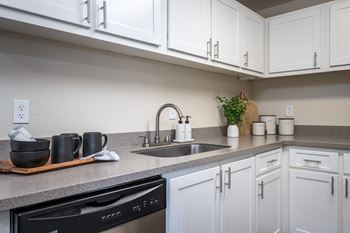 a kitchen with white cabinets and a sink at Sundial Apartments, Wilsonville, 97070
